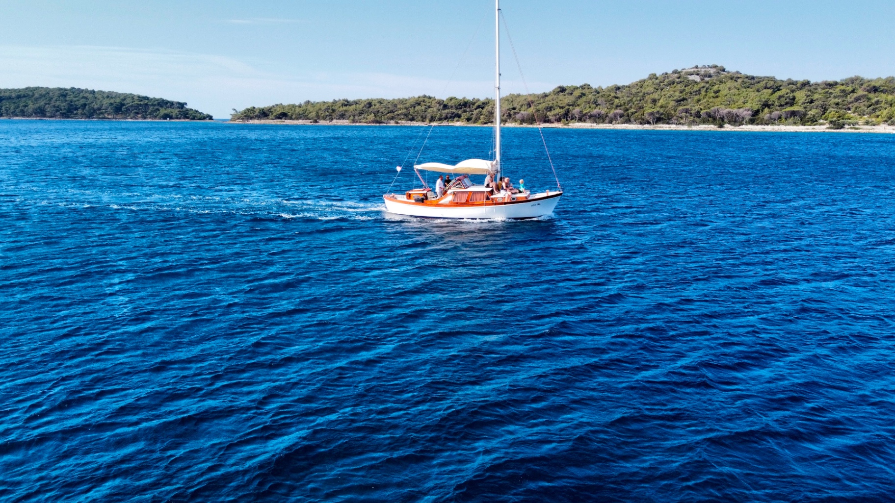Traditional Croatian gulet cruising past pine-covered islands